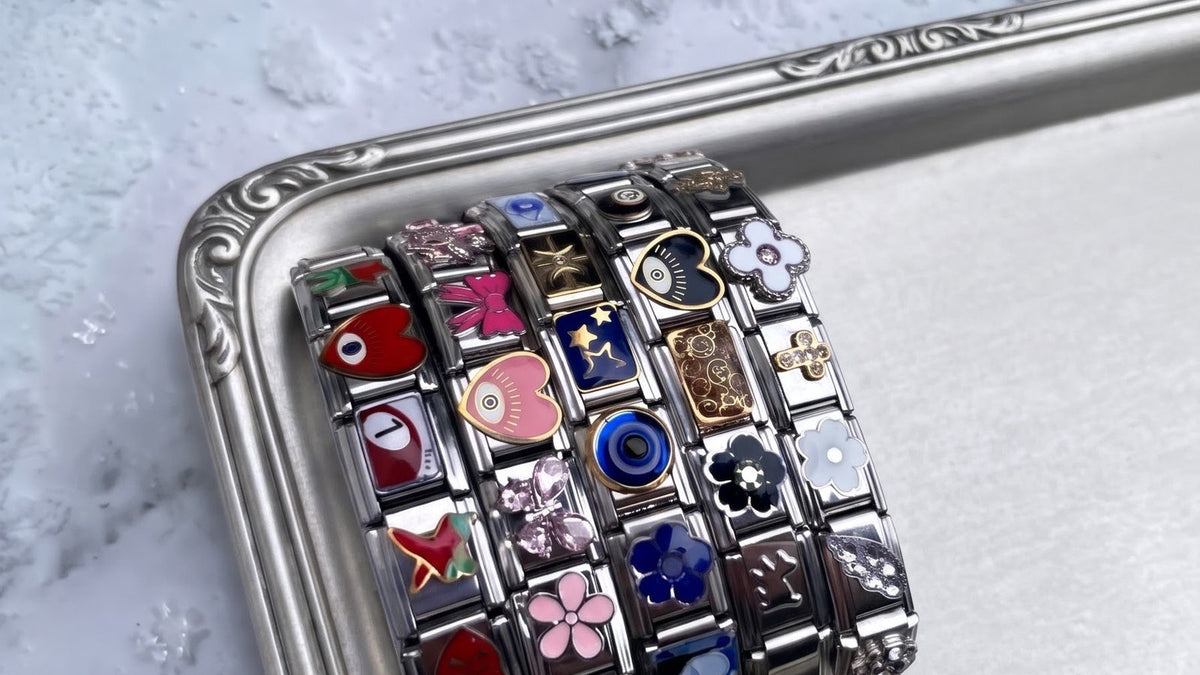 Bracelets italiens argentés composés de charms colorés, posés sur un plateau